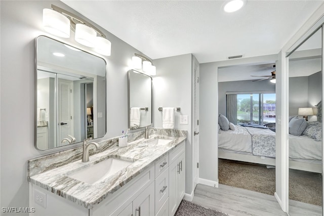 bathroom with ceiling fan, vanity, a textured ceiling, and hardwood / wood-style flooring