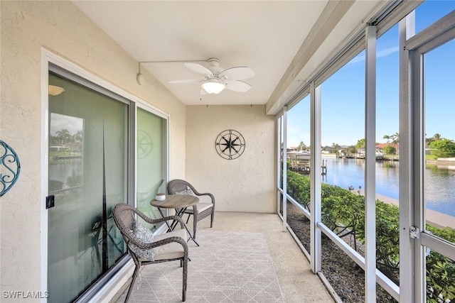 sunroom with a water view and ceiling fan