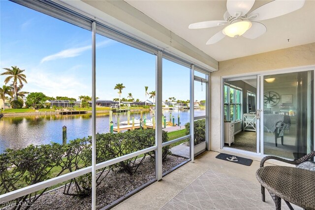 sunroom featuring a water view and ceiling fan