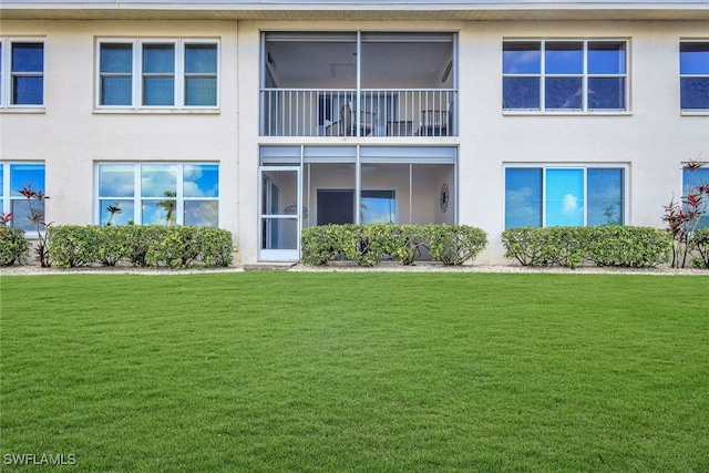 back of property featuring a lawn