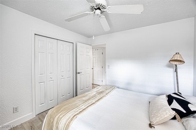 bedroom with ceiling fan, light hardwood / wood-style flooring, and a closet