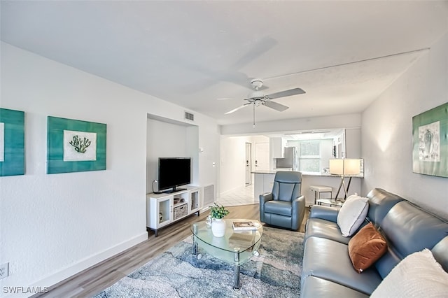 living room with wood-type flooring and ceiling fan