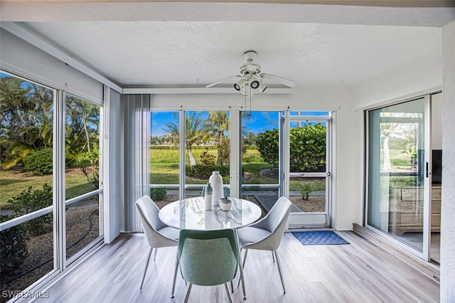 unfurnished sunroom with ceiling fan