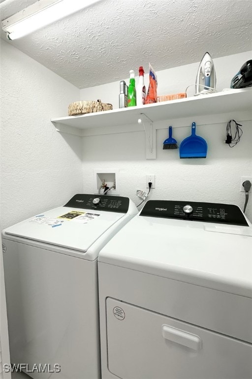 washroom with a textured ceiling and washer and clothes dryer