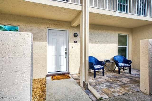 view of exterior entry with a balcony