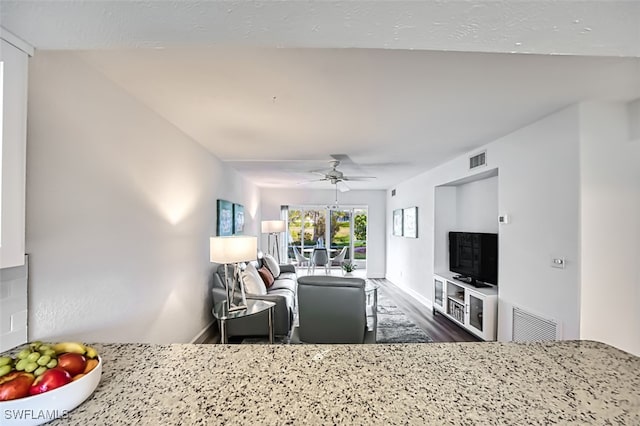 living room featuring ceiling fan and dark hardwood / wood-style flooring