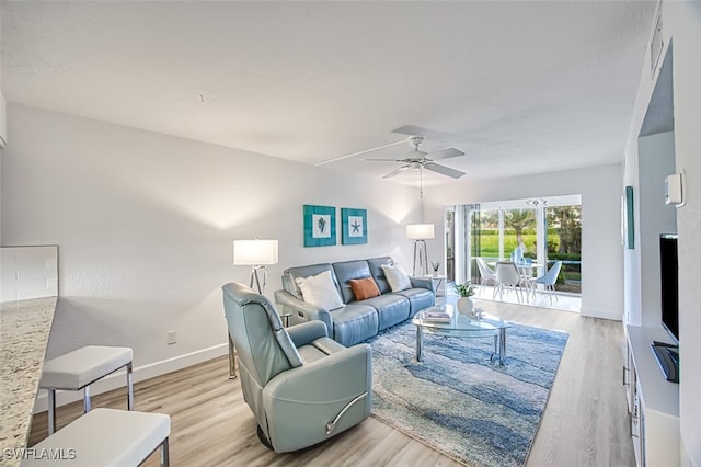 living room featuring ceiling fan and light hardwood / wood-style floors