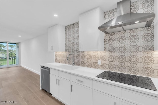 kitchen with decorative backsplash, a sink, stainless steel dishwasher, wall chimney range hood, and black electric cooktop