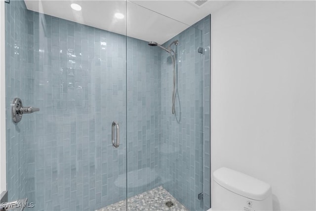 full bath featuring a shower stall and toilet