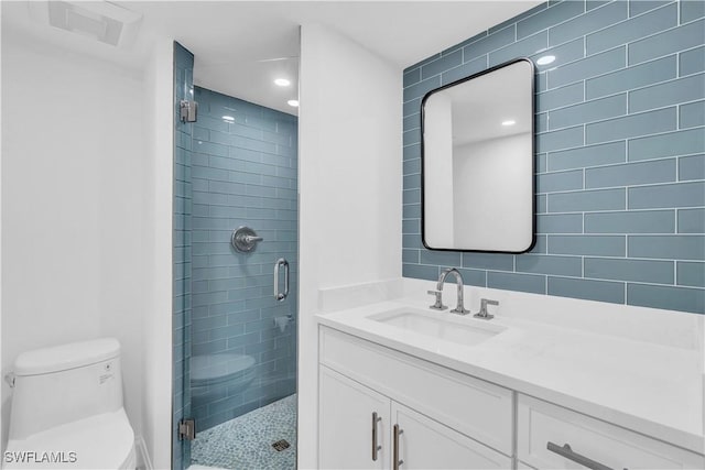 bathroom with vanity, toilet, visible vents, and a stall shower