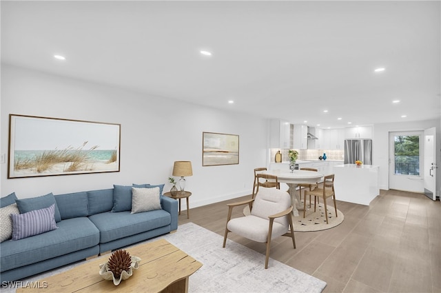 living room with recessed lighting, baseboards, and light wood-style floors