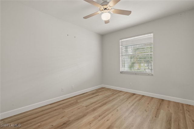 empty room with ceiling fan and light hardwood / wood-style flooring