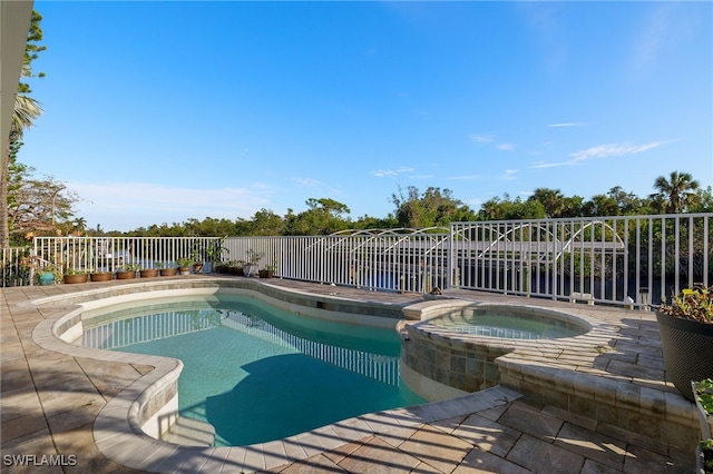 view of pool featuring an in ground hot tub and a patio