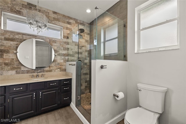 bathroom with toilet, vanity, a chandelier, and walk in shower