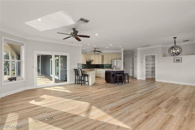 kitchen with a kitchen breakfast bar, crown molding, pendant lighting, stainless steel fridge with ice dispenser, and a kitchen island