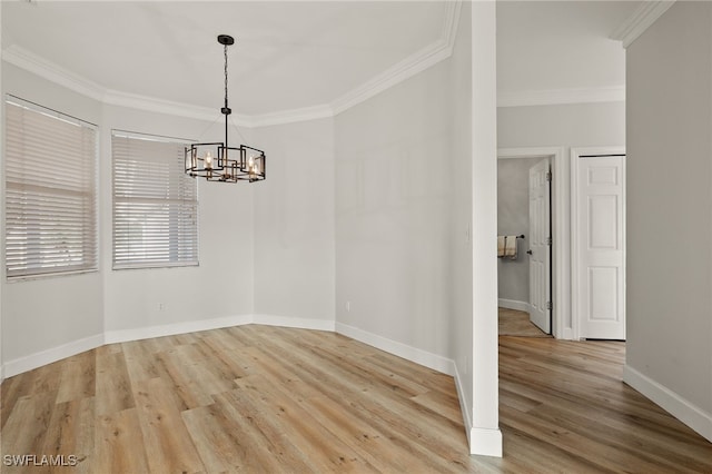 empty room with crown molding, light wood-type flooring, and a notable chandelier