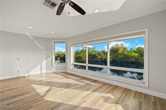 spare room with light wood-type flooring, ceiling fan, and ornamental molding