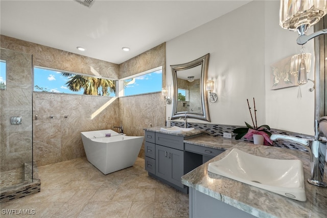 bathroom featuring vanity, tile walls, and shower with separate bathtub