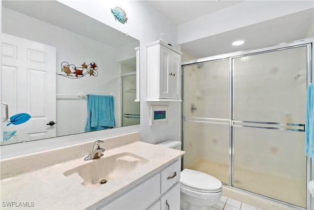 bathroom featuring toilet, vanity, tile patterned floors, and a shower with shower door