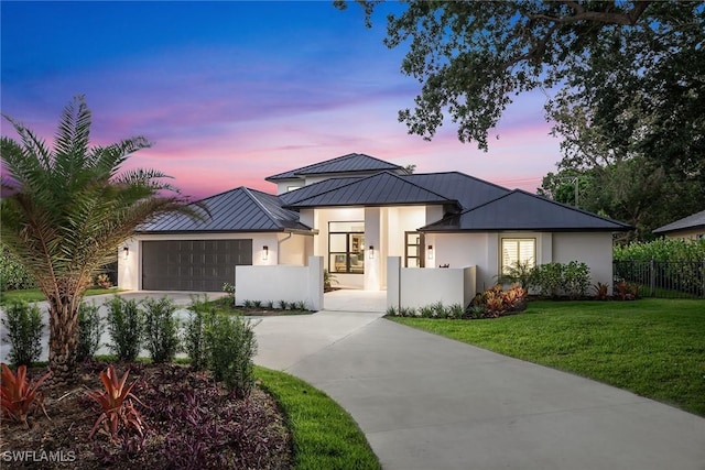 view of front of home featuring a garage and a lawn