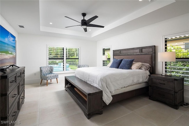 bedroom featuring a tray ceiling, ceiling fan, and light tile patterned floors