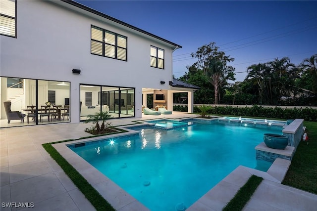 view of swimming pool featuring pool water feature, a patio area, and an in ground hot tub