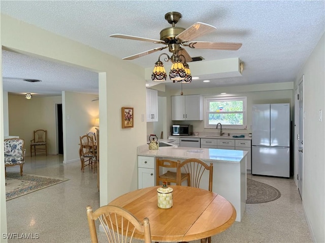 kitchen featuring a textured ceiling, sink, white cabinetry, and stainless steel appliances