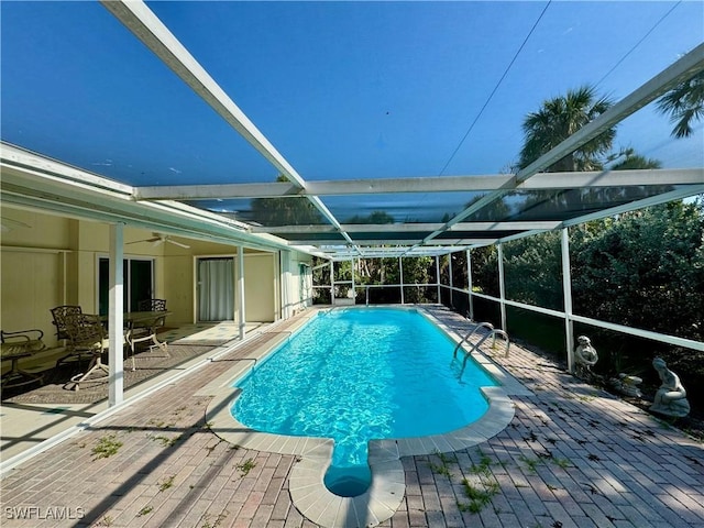 view of pool with ceiling fan, a patio area, and a lanai