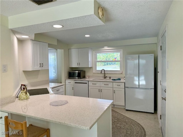 kitchen with kitchen peninsula, stainless steel appliances, and white cabinetry