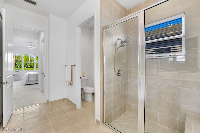 bathroom with a shower with shower door, tile patterned floors, and toilet