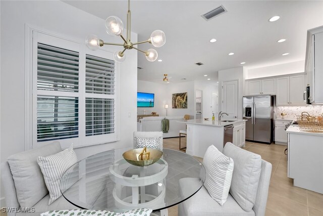 tiled dining area with sink and a notable chandelier