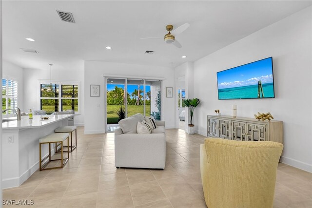 tiled living room featuring sink and ceiling fan