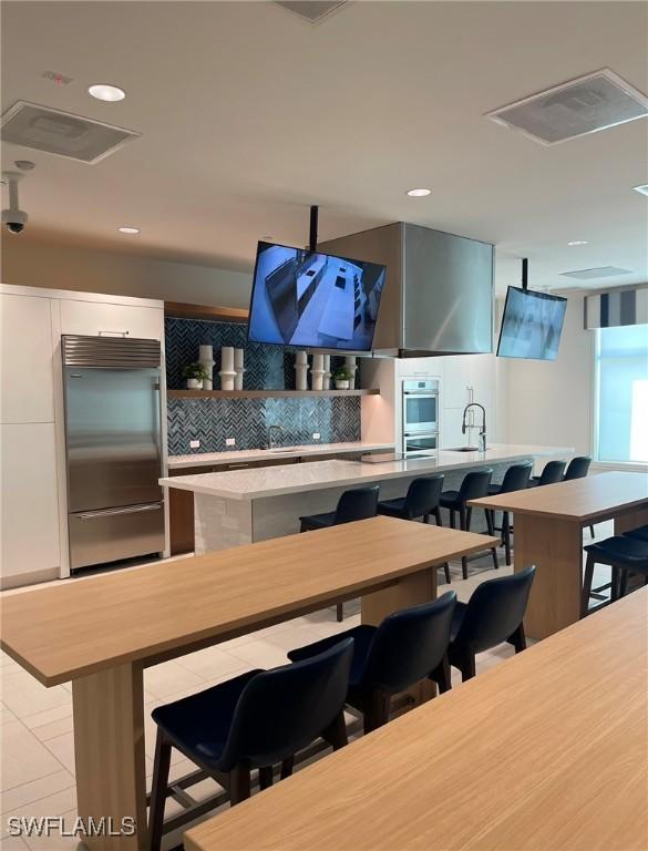 kitchen featuring tasteful backsplash, a kitchen island, a breakfast bar area, and appliances with stainless steel finishes