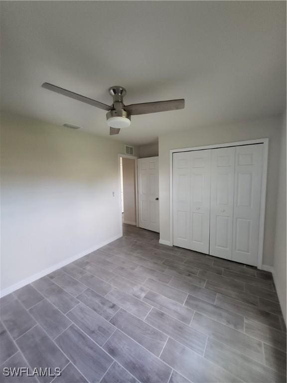 unfurnished bedroom featuring hardwood / wood-style floors, a closet, and ceiling fan