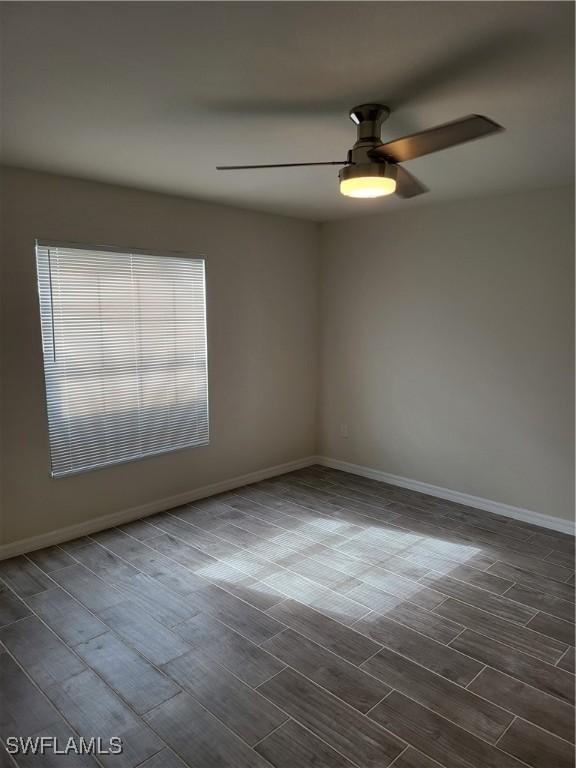 spare room featuring dark hardwood / wood-style flooring and ceiling fan