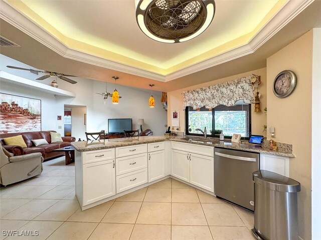 kitchen featuring white cabinetry, a raised ceiling, stainless steel dishwasher, and sink