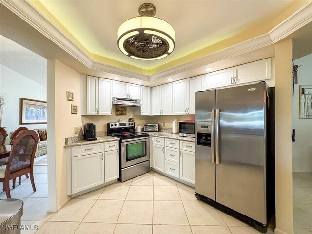 kitchen with a raised ceiling, white cabinetry, light stone countertops, and stainless steel appliances