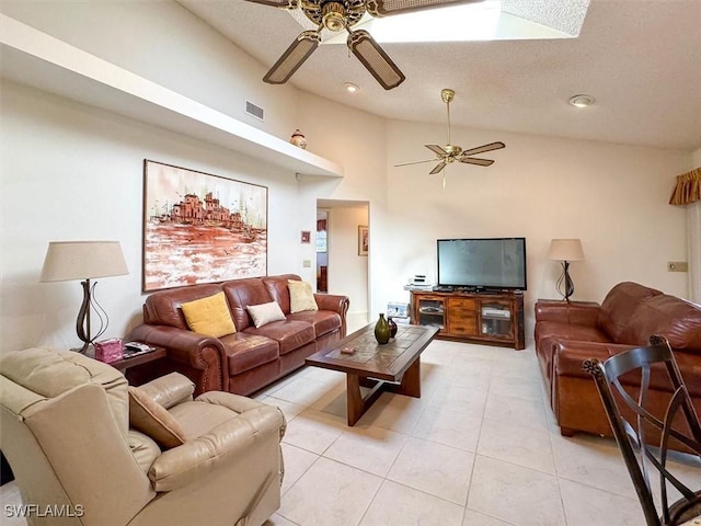 living room with ceiling fan, light tile patterned flooring, a textured ceiling, and high vaulted ceiling