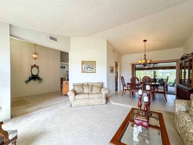 living room with lofted ceiling, light carpet, a textured ceiling, and an inviting chandelier