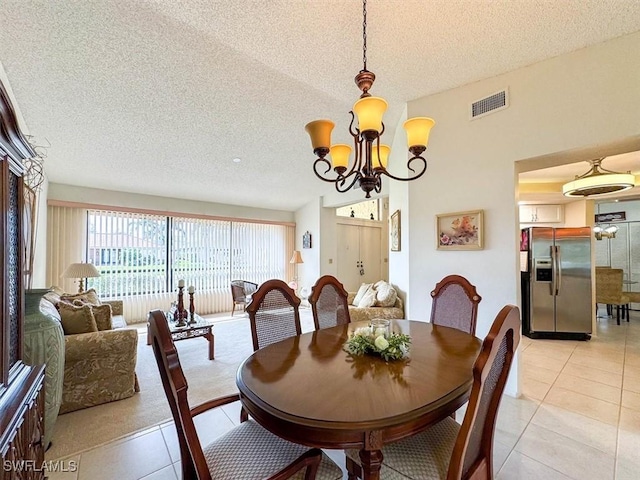 dining room featuring a chandelier, a textured ceiling, and light tile patterned flooring