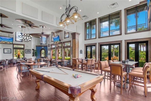 game room with hardwood / wood-style floors, a high ceiling, french doors, ceiling fan, and pool table