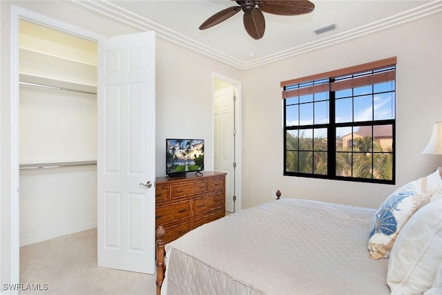 carpeted bedroom featuring ceiling fan, a closet, and ornamental molding