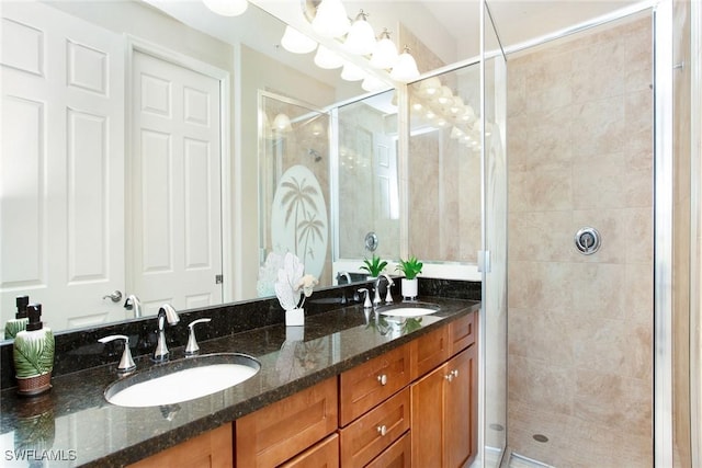 bathroom featuring a shower with door and vanity