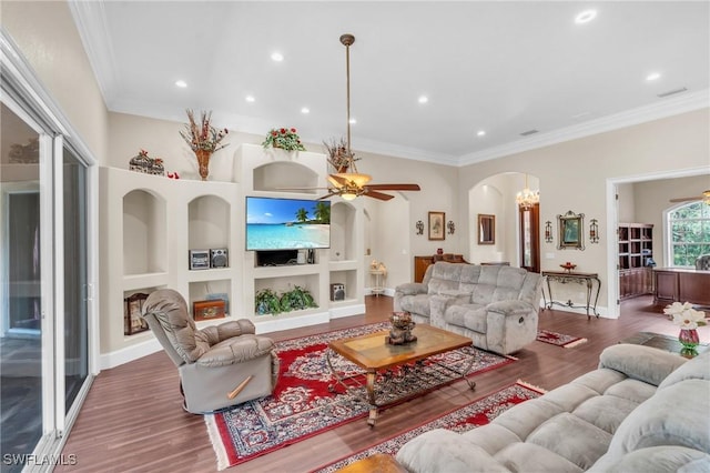 living room with ceiling fan, built in features, and crown molding