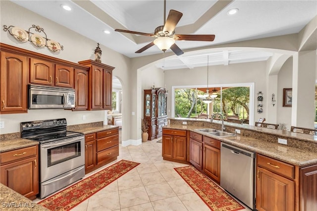 kitchen with light stone countertops, sink, ceiling fan, stainless steel appliances, and light tile patterned floors