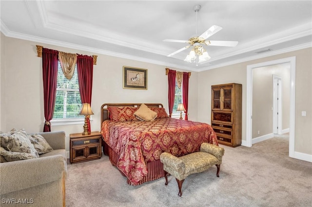 carpeted bedroom featuring ceiling fan, crown molding, and a tray ceiling