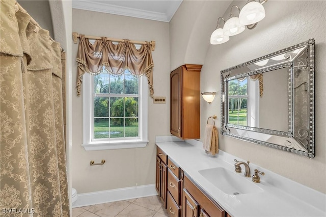 bathroom with a healthy amount of sunlight, vanity, tile patterned floors, and crown molding