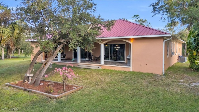 rear view of house with a lawn, a patio area, and central AC unit