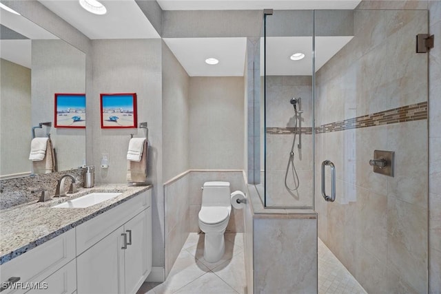 bathroom featuring toilet, an enclosed shower, tile walls, and vanity