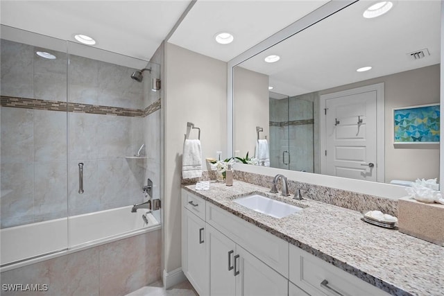 bathroom featuring vanity and combined bath / shower with glass door